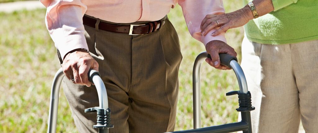 Ein älterer Mann stützt sich auf einen Rollator