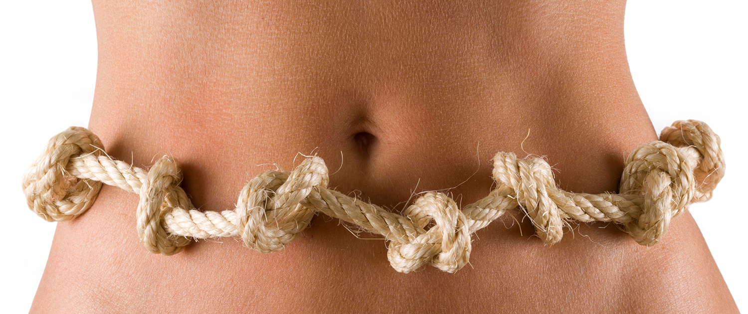 Ein um einen nackten Bauch geschlungenes Seil mit vielen Knoten