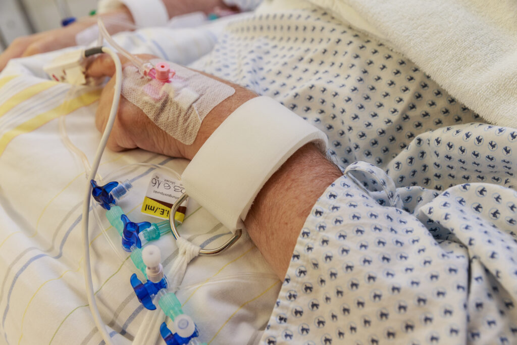 Ältere Patientin mit Fixierungsgurt am Handgelenk