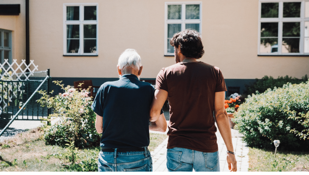 Nachbarschaftshilfe: Ein älterer und ein deutlich jüngerer Mann gehen spazieren.