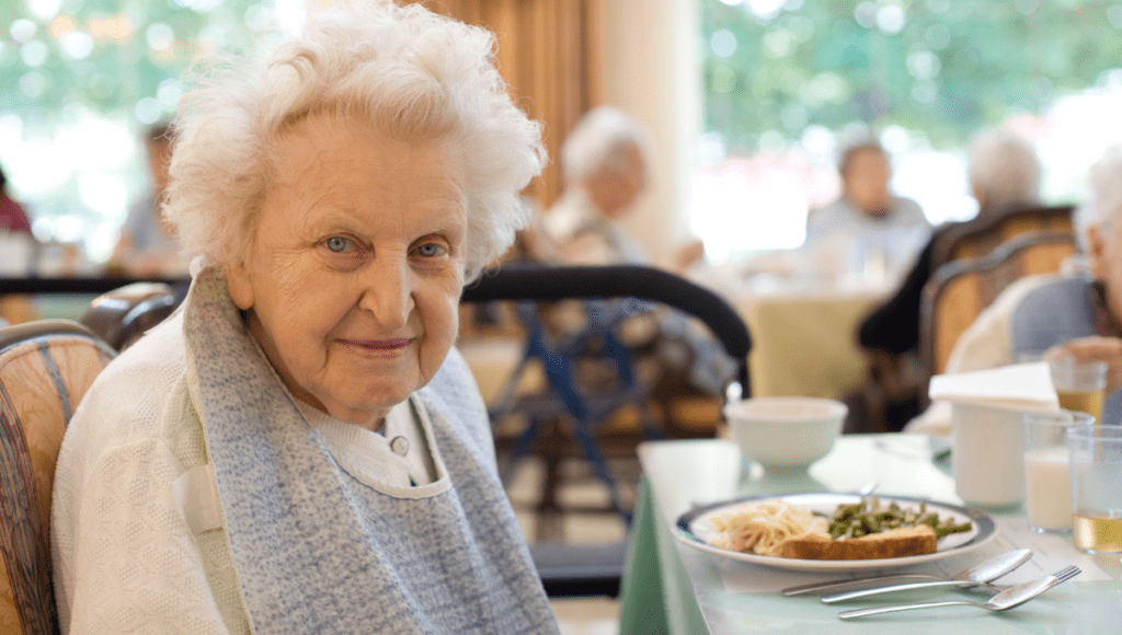 Eine Seniorin in der Kurzzeitpflege beim Essen im Heim.
