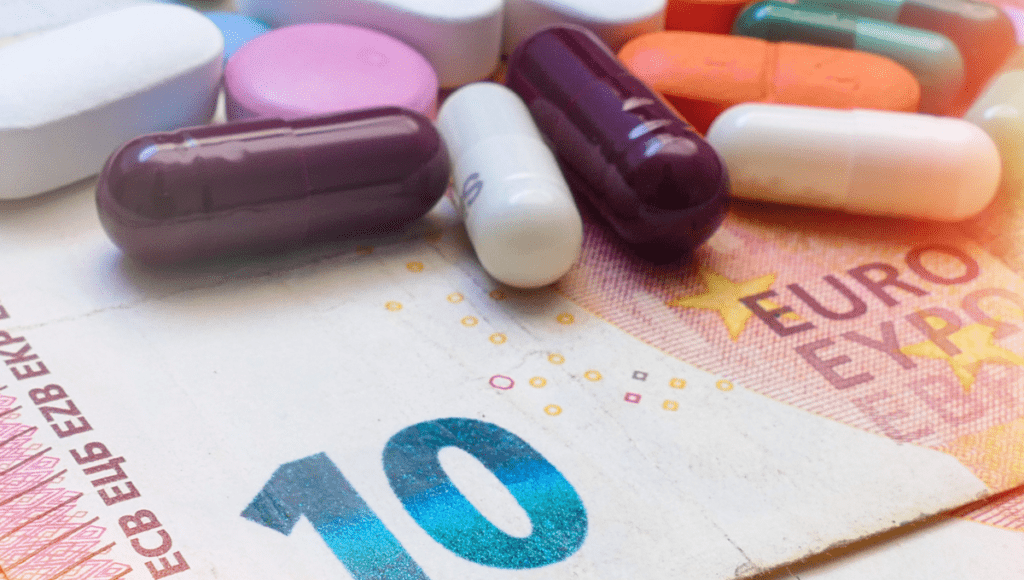 Ein Geldschein und Tabletten stehen sinnbildlich für die Zuzahlung für ein Medikament.